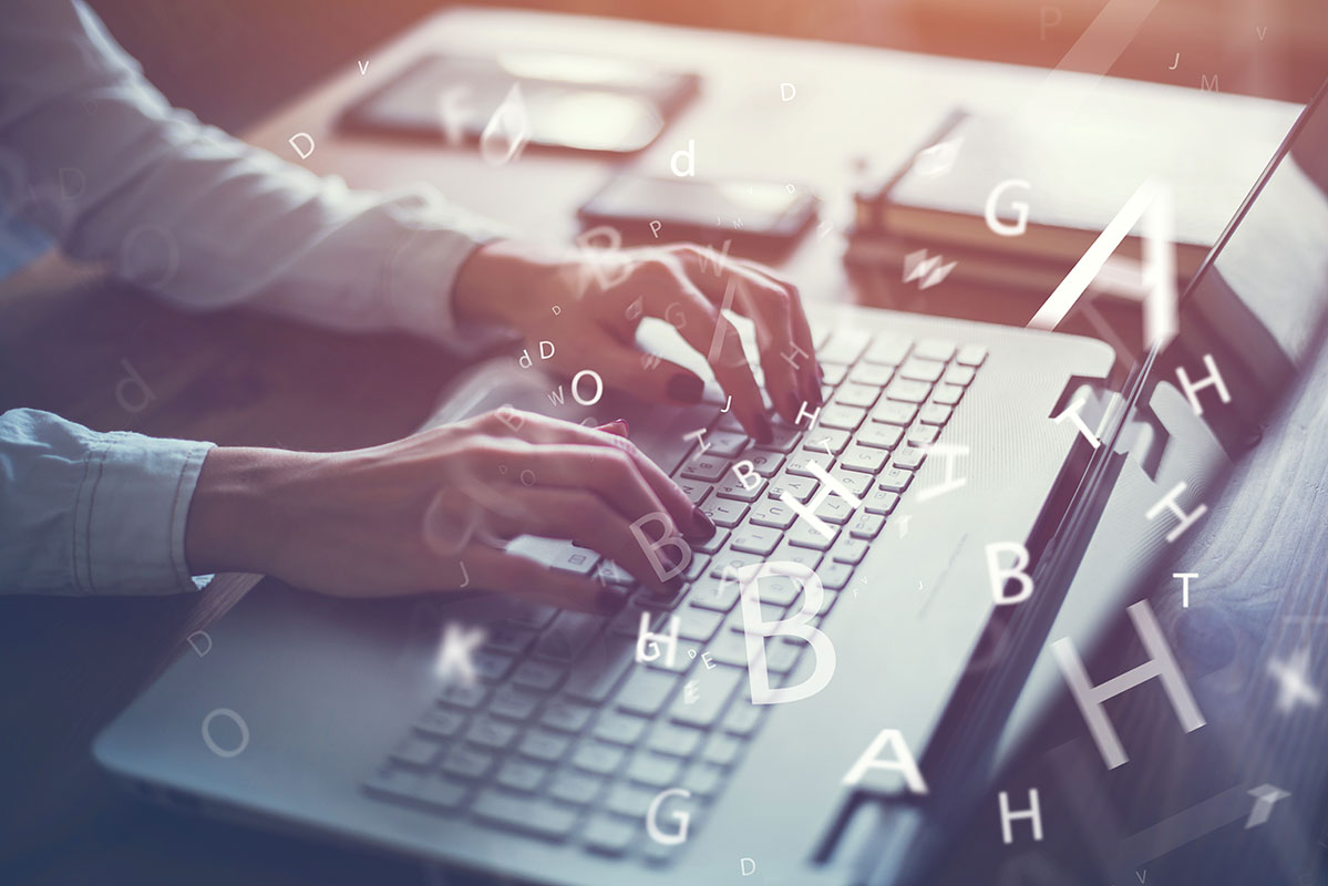 Photo of a woman typing at a keyboard and letters flying through the air